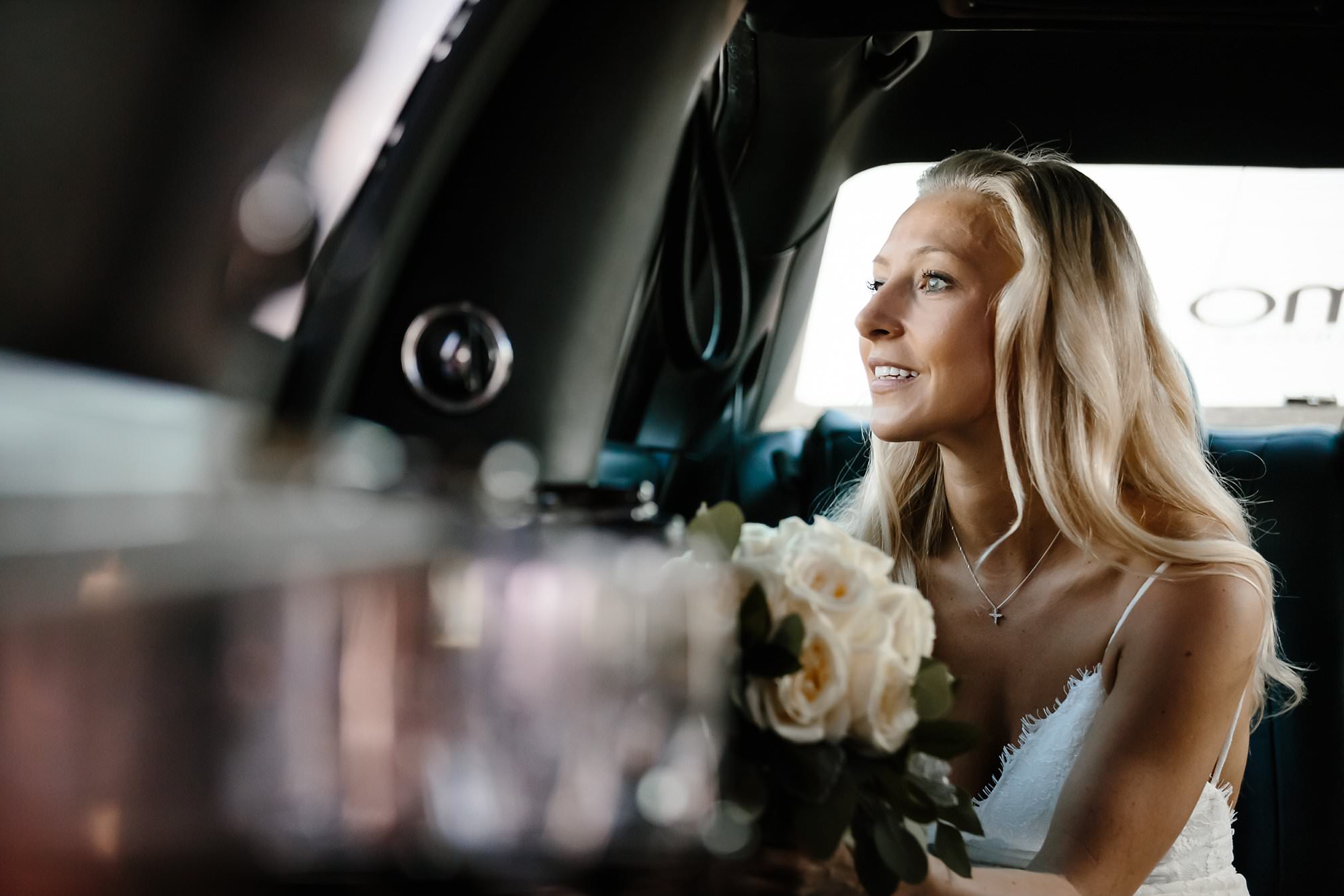 Blond bride looking out limo window