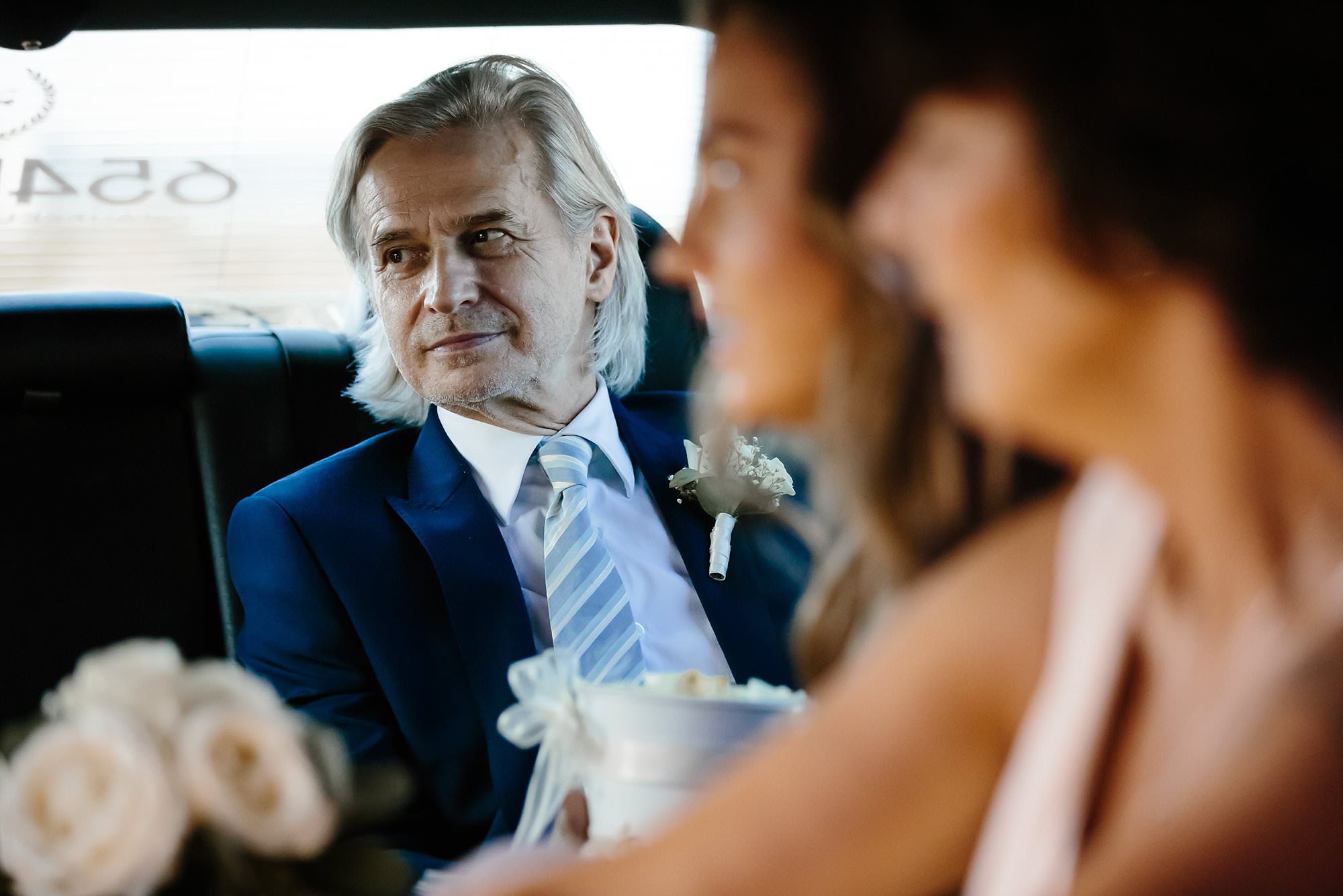 Father of the bride wearing blue suit in a limo