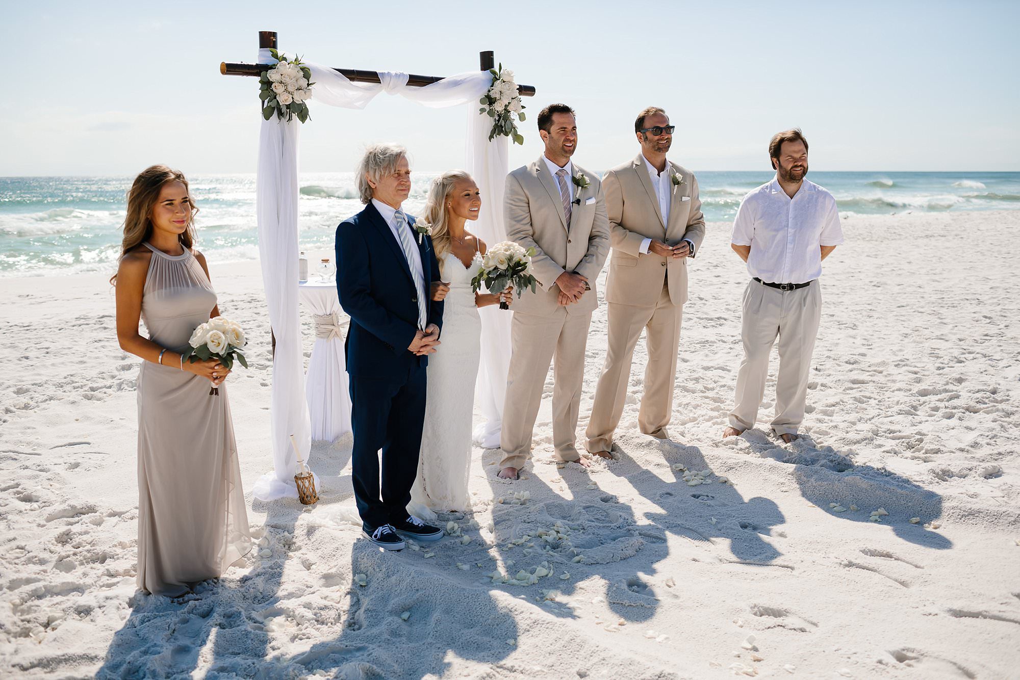 Wedding Party in front of bamboo arbor facing guests at beach wedding at Henderson State Park in Destin