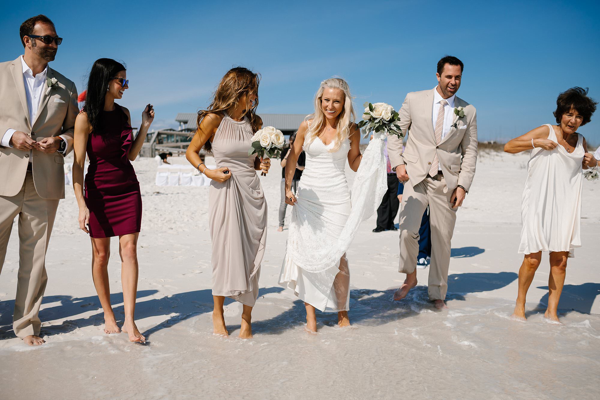 Wedding party and guests standing at the waters edge for shell tossing ceremony on the beach Destin Florida