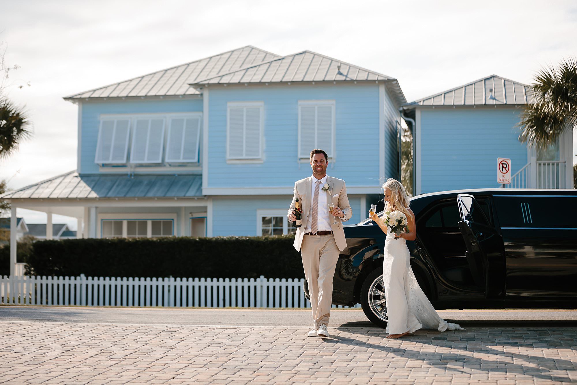 Bride and Groom exiting limo in front of Aqua Viva beach house for wedding reception