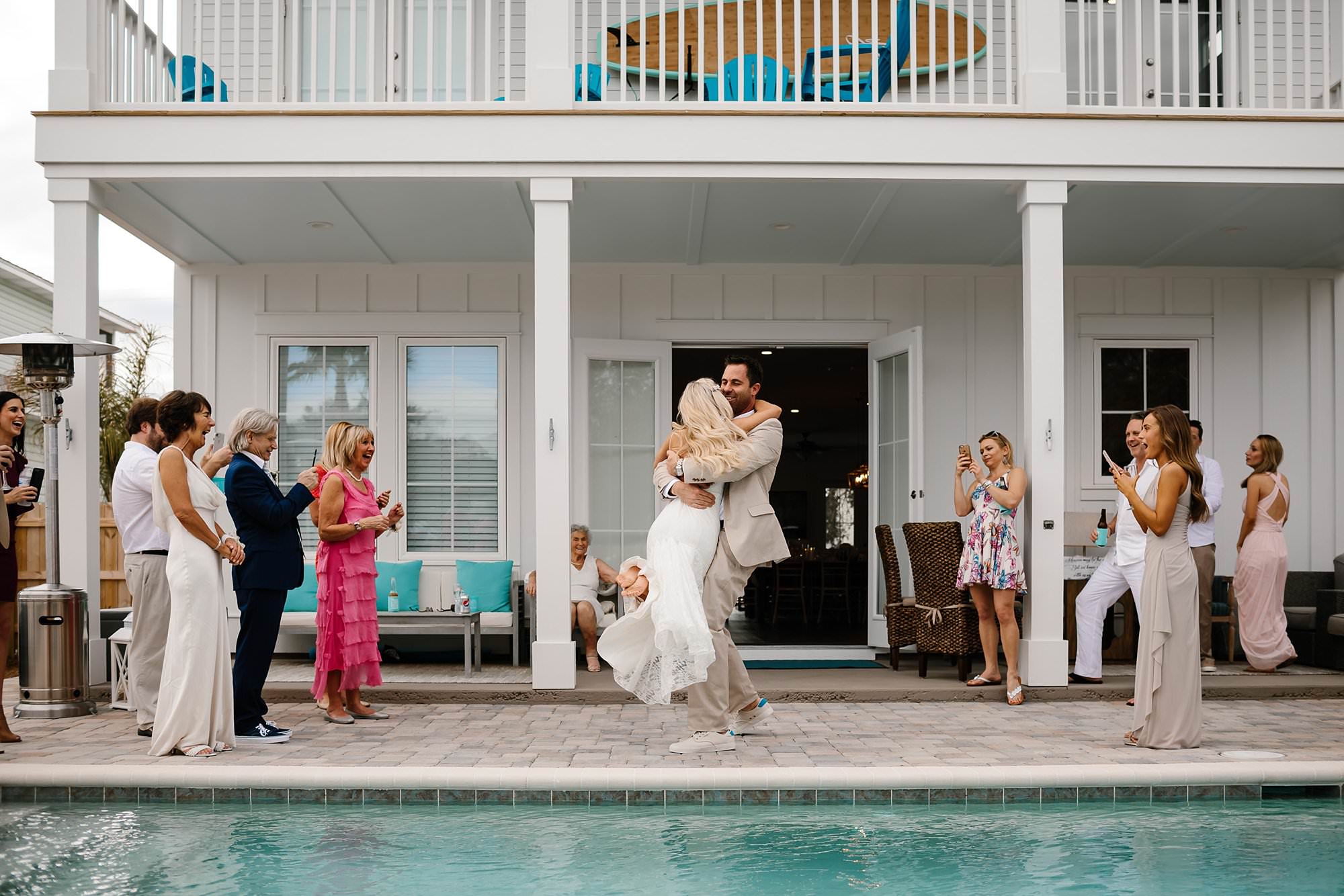 Groom spinning bride during grand entrance into wedding reception at beach house in Destin