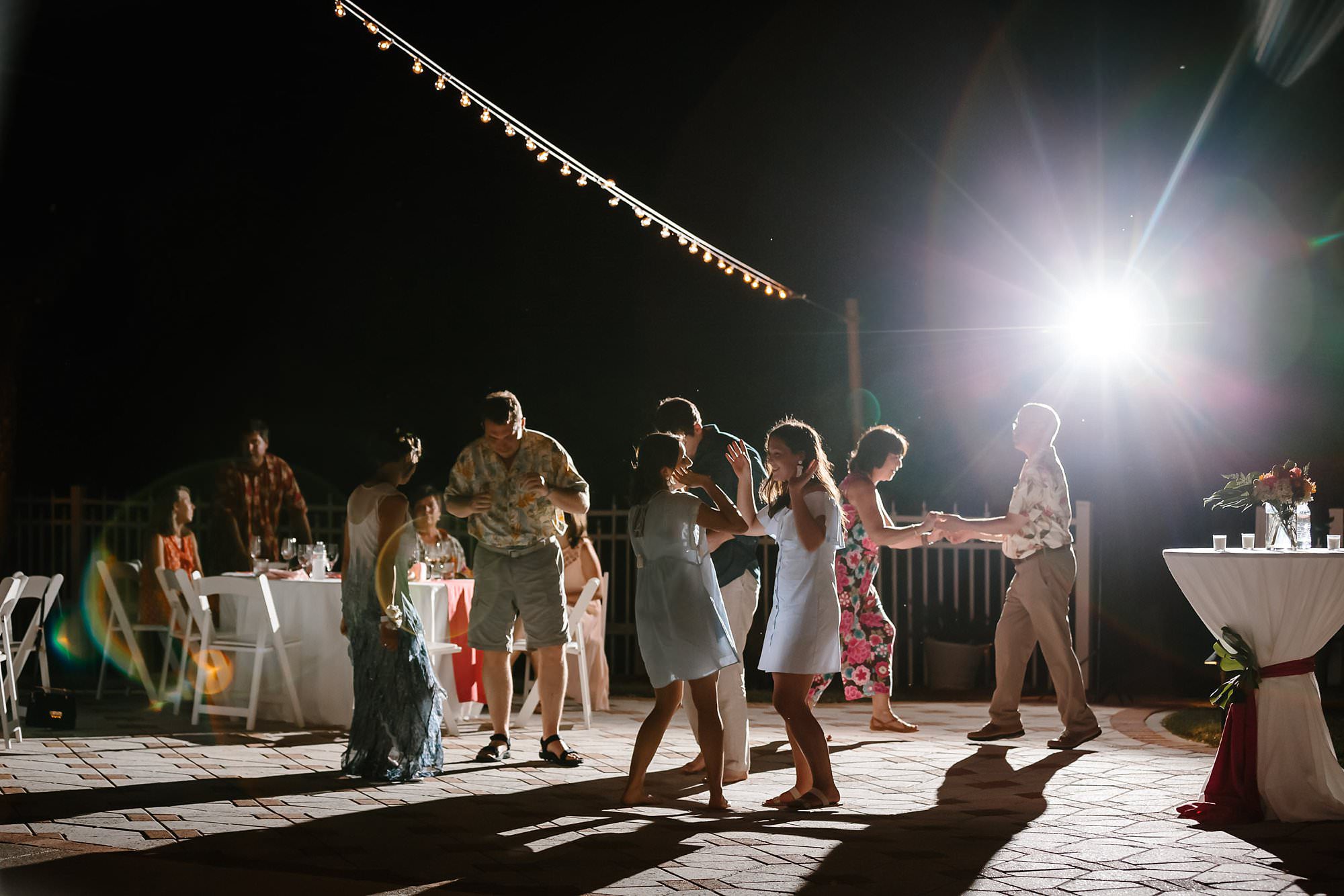 Guests dancing at outdoor reception around pool at Aisle of Palms beach house on St. George Island