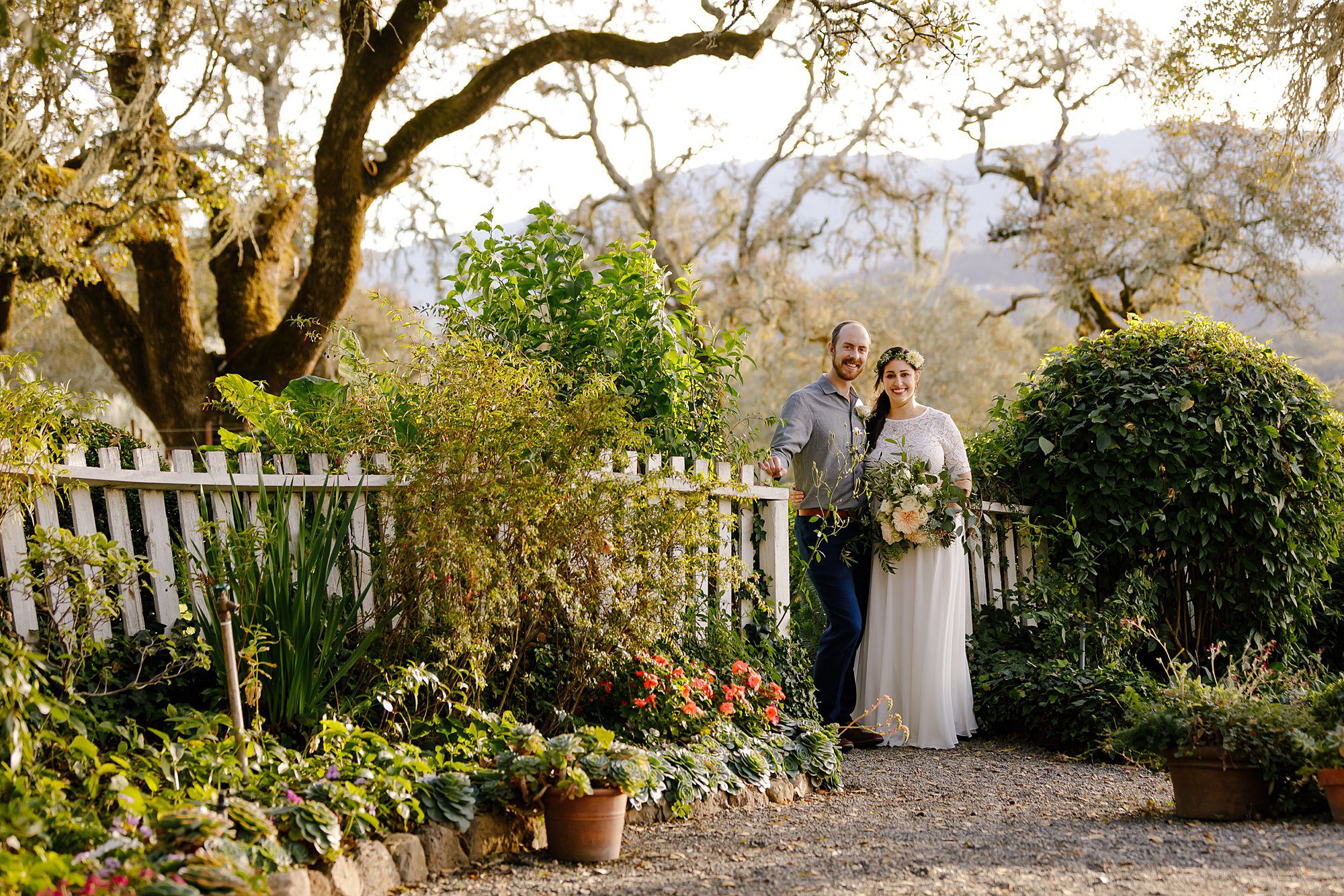 Angie and Tyler in the in the gardens at Beltane Ranch where they eloped under the oak tree