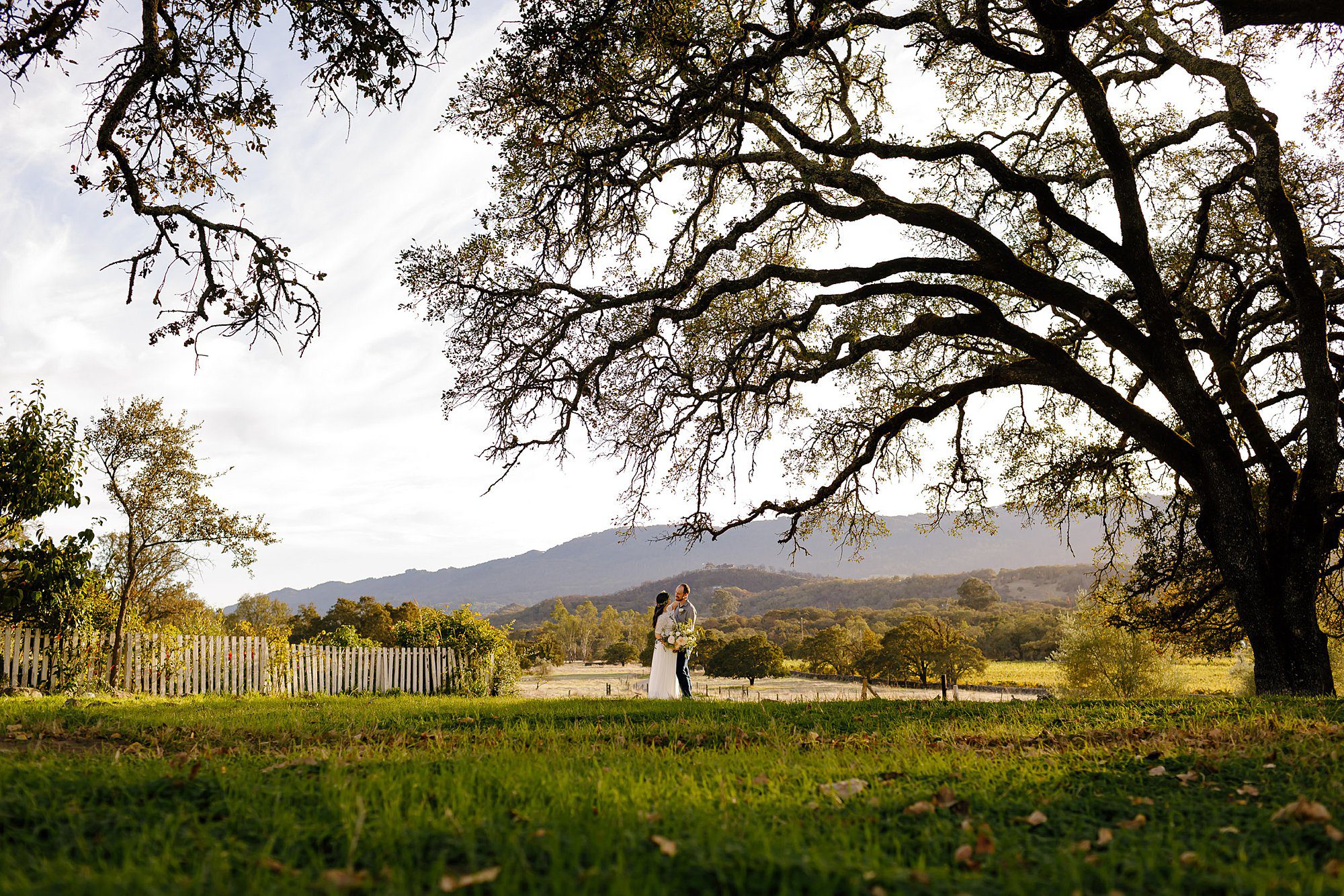 Angie and Tyler embracing in a private moment with the Sonoma mountains behind them at Beltane Ranch in Glenn Ellen