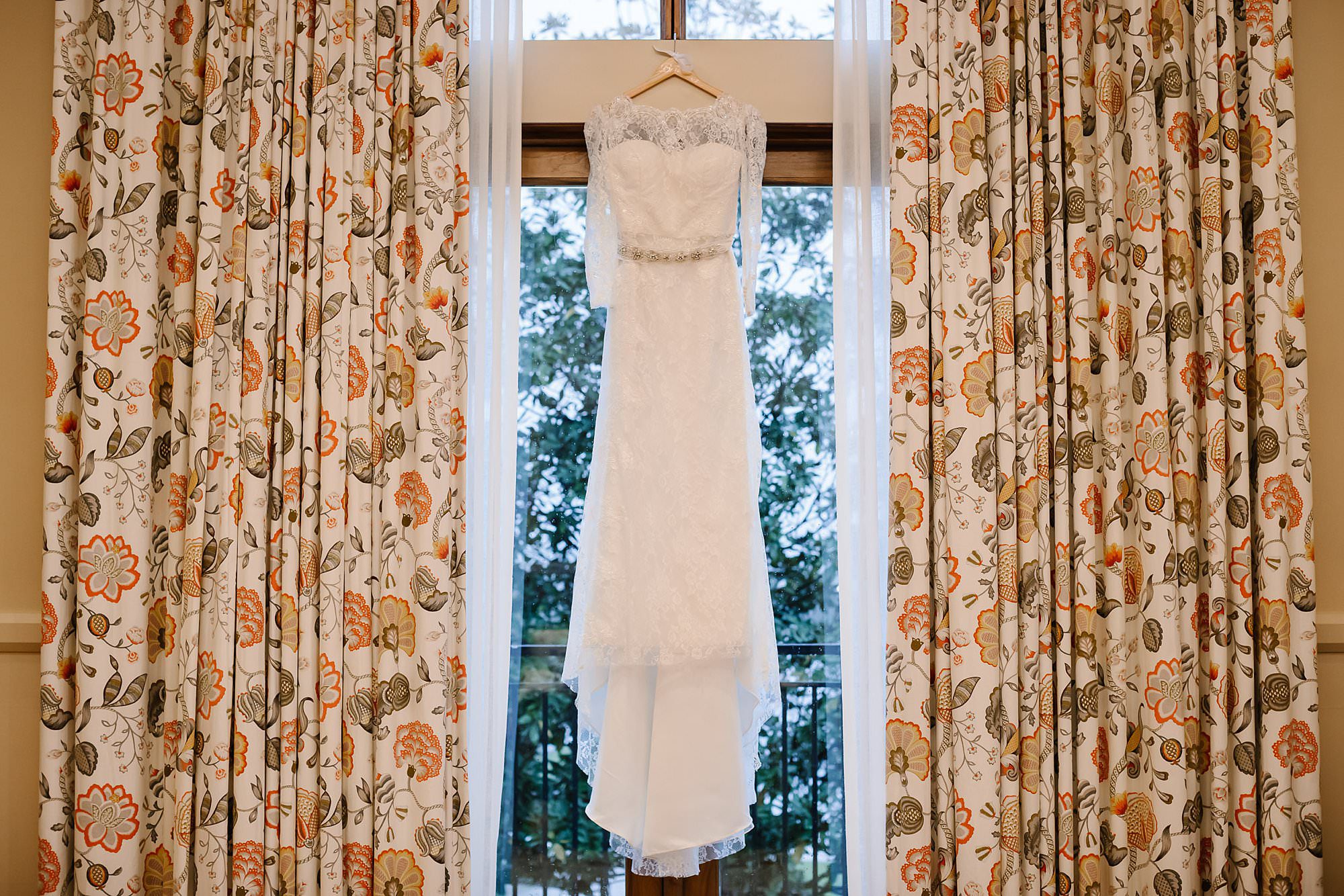 Lace sleeved wedding dress hanging in the bridal suite at Henderson Beach Resort and Spa