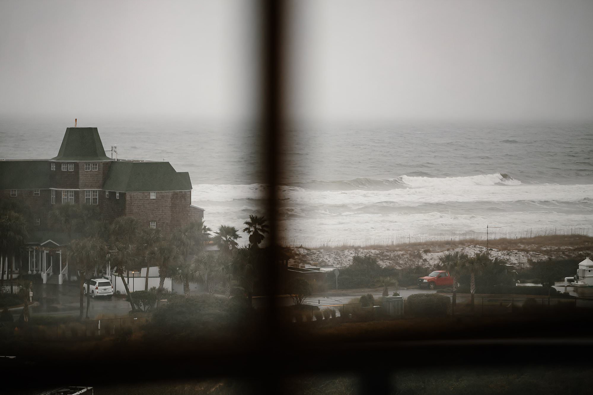 View through the window of the rainy beach from Henderson Beach Resort and Spa