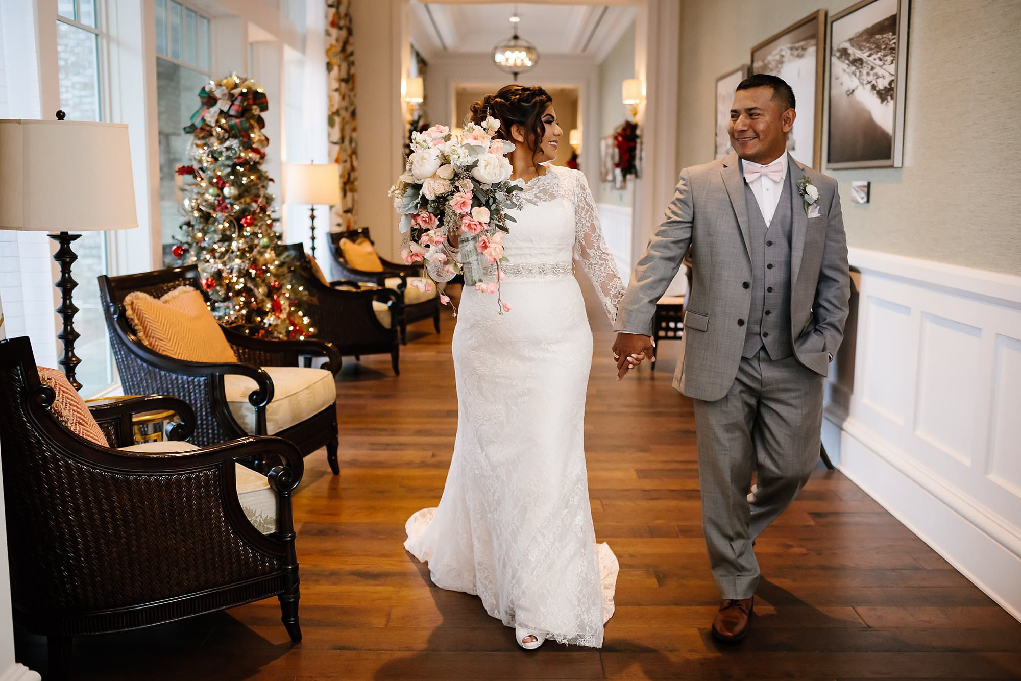 Bride and groom walking down the hall at Henderson Beach Resort and Spa on their way to meet their wedding party