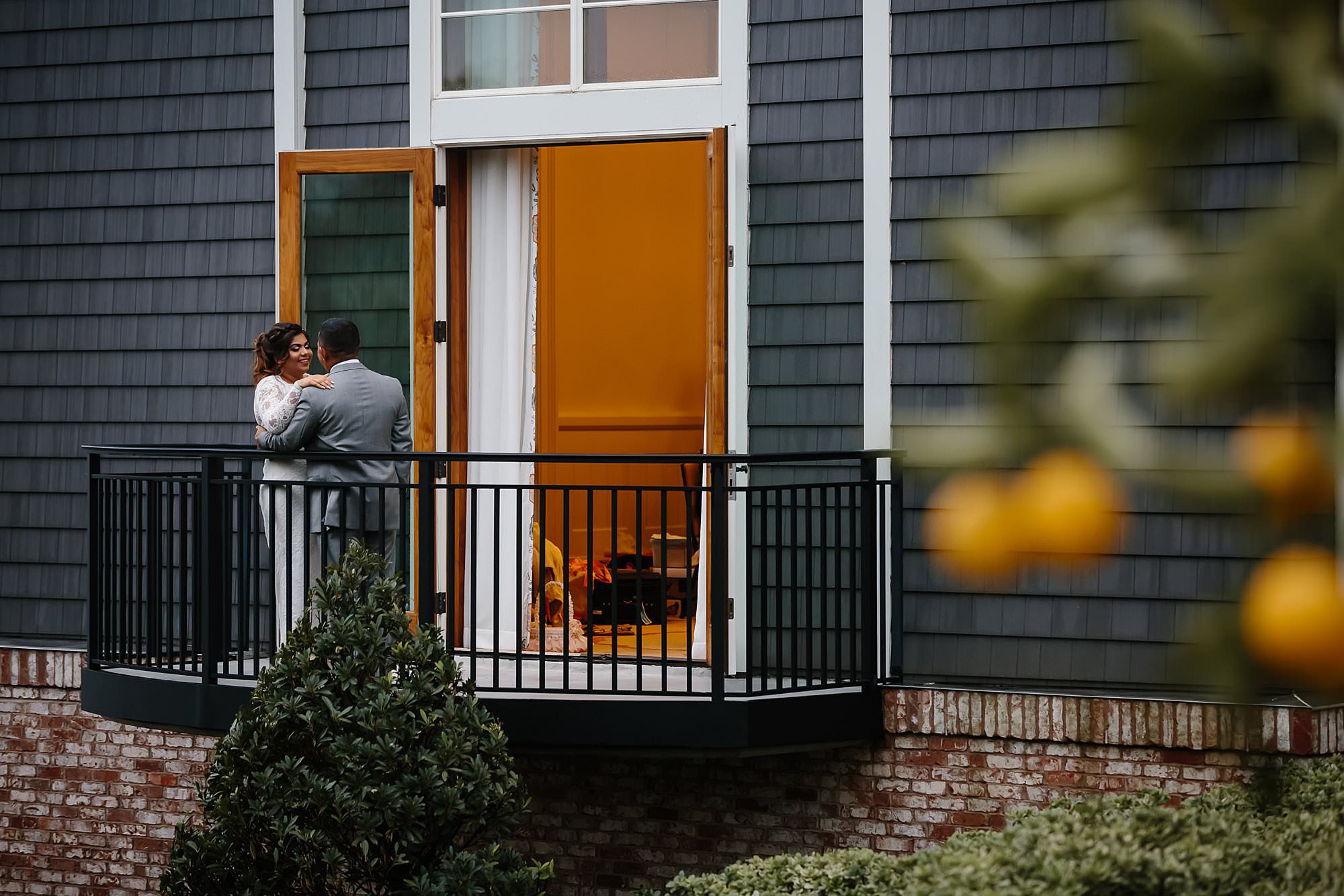 Bride and groom on the balcony of the bridal suite at the Henderson Beach Resort and Spa durning a break in the rain