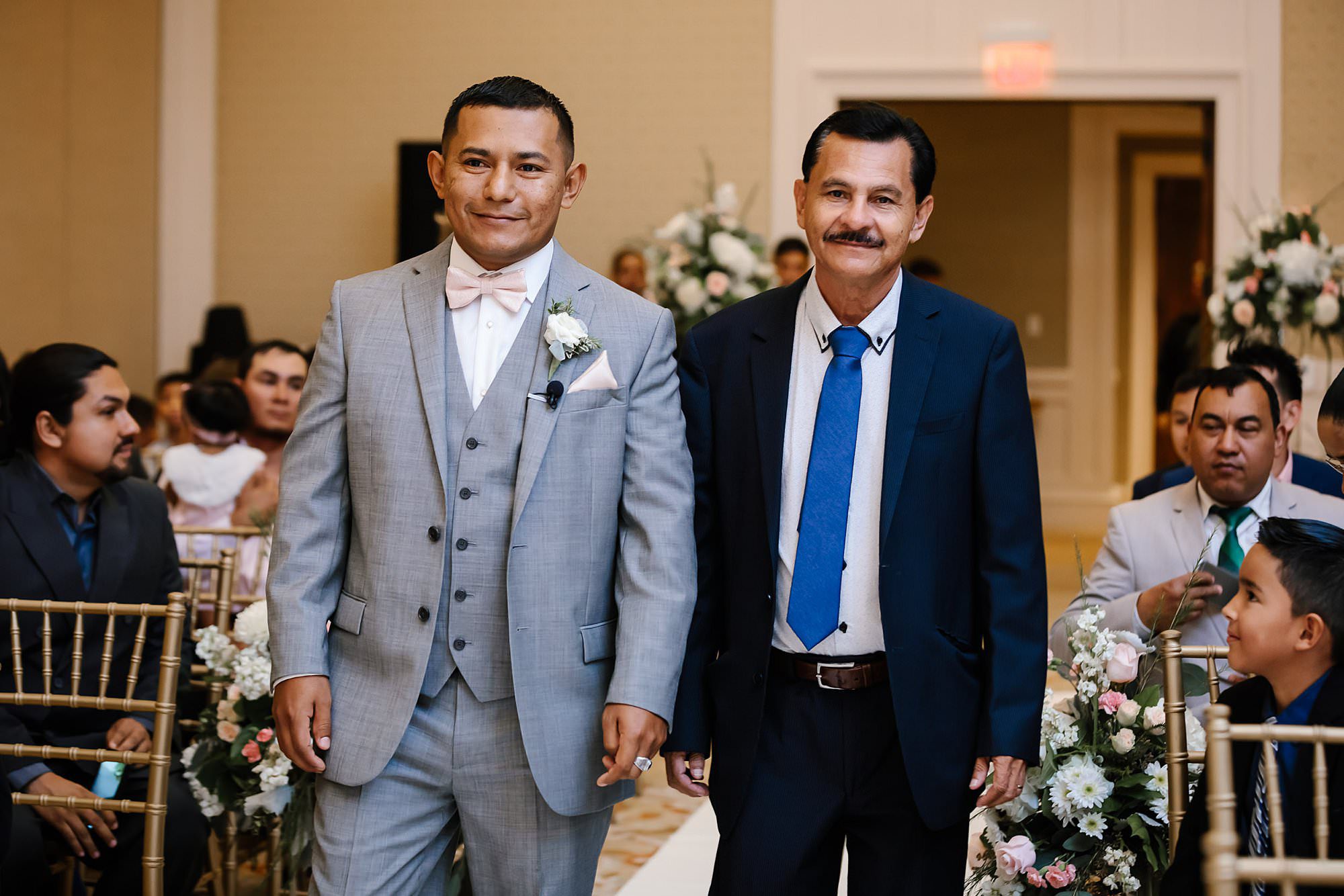 Groom and uncle walking down the aisle at their indoor wedding at Henderson Beach Resort and Spa