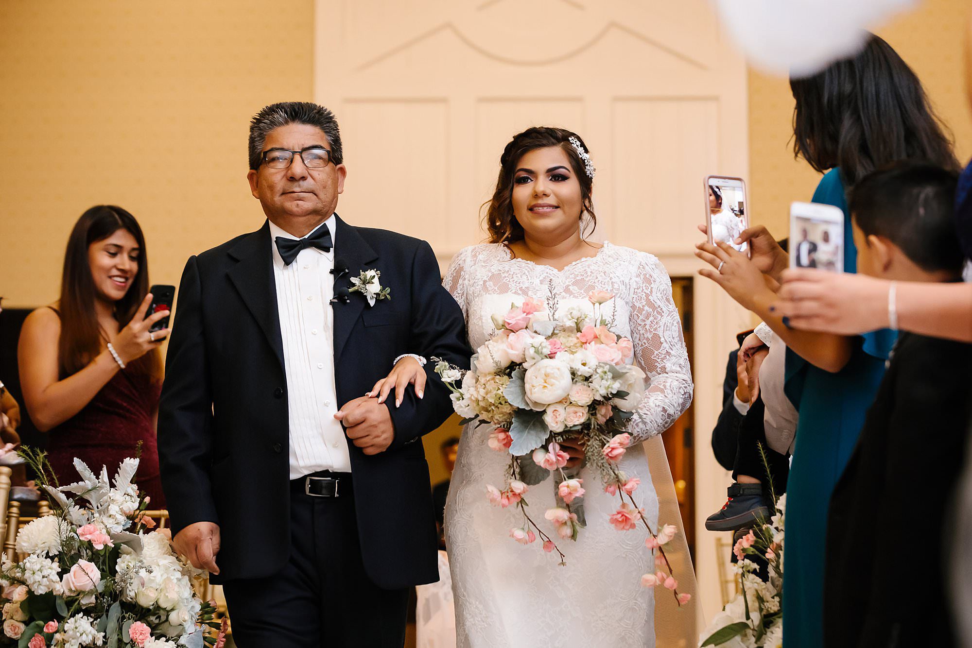 Bride and her father walking down the aisle at their indoor wedding at Henderson Beach Resort and Spa