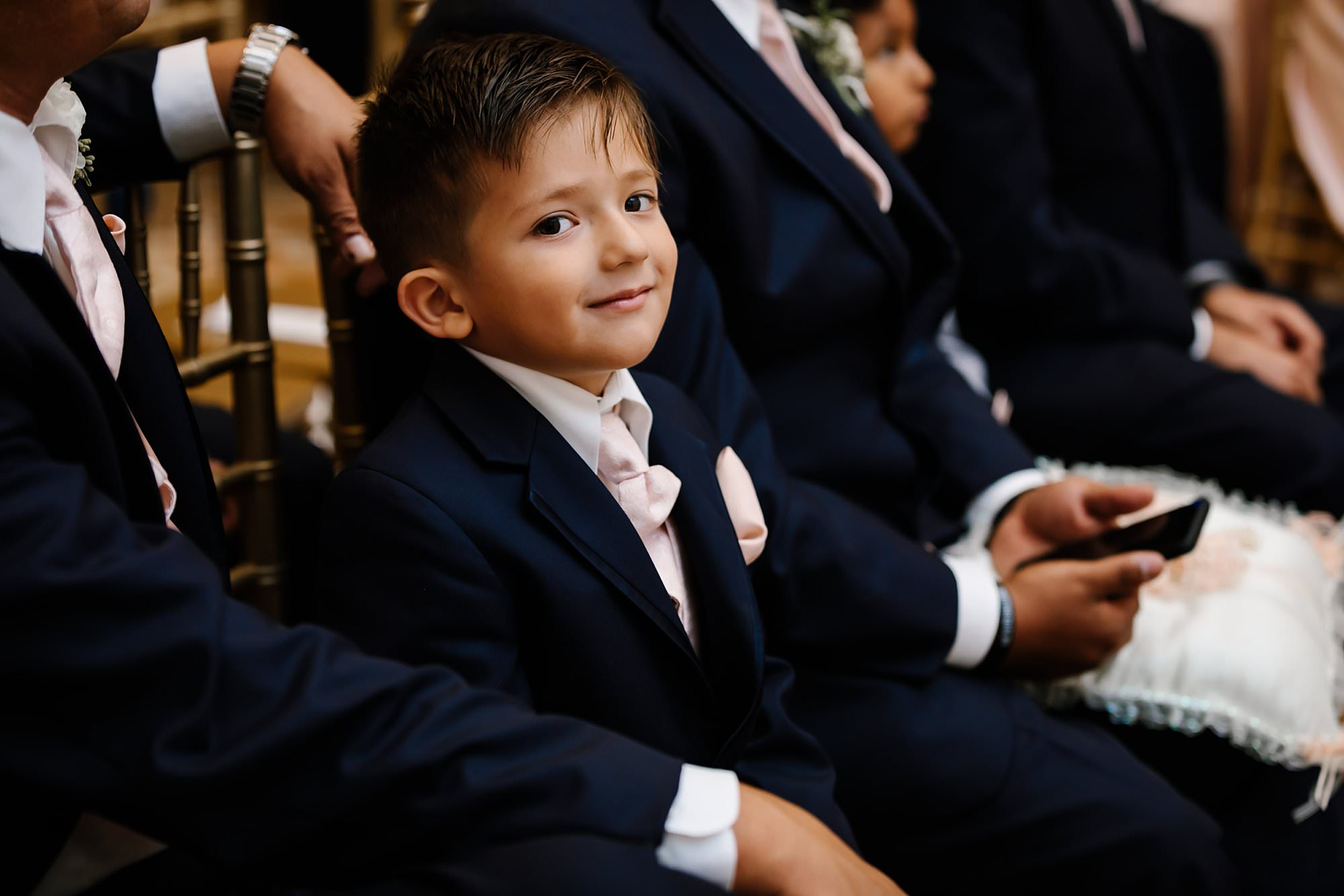 Ring bearer smiling at the camera during the ceremony
