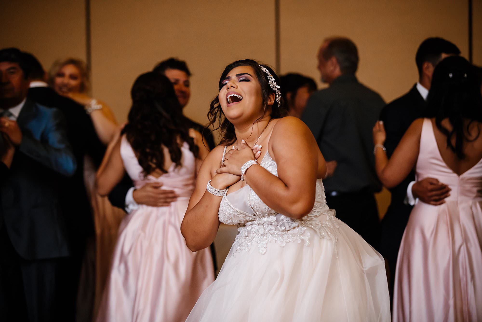 Bride singing to her favorite song during first dance with entire wedding party