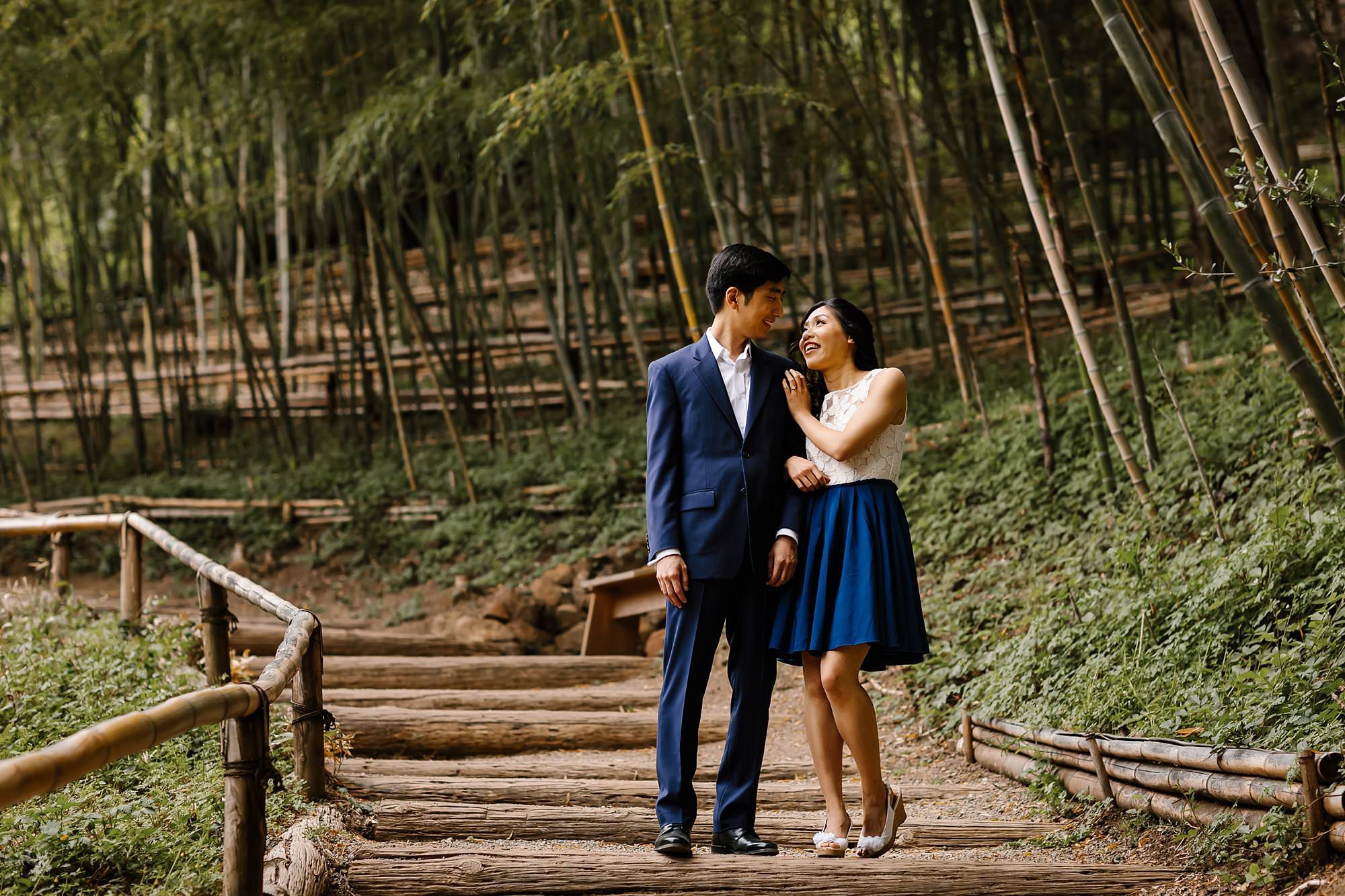 Engaged couple walking through the bamboo path at Hakone Estate