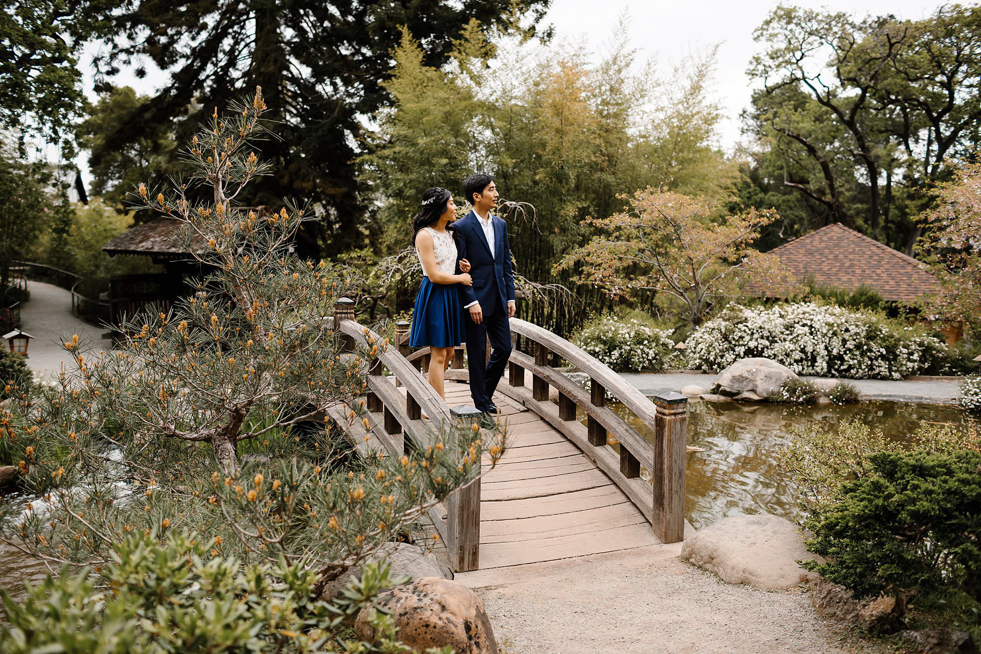 Engaged couple walking over bridge in Hakone Estate gardens