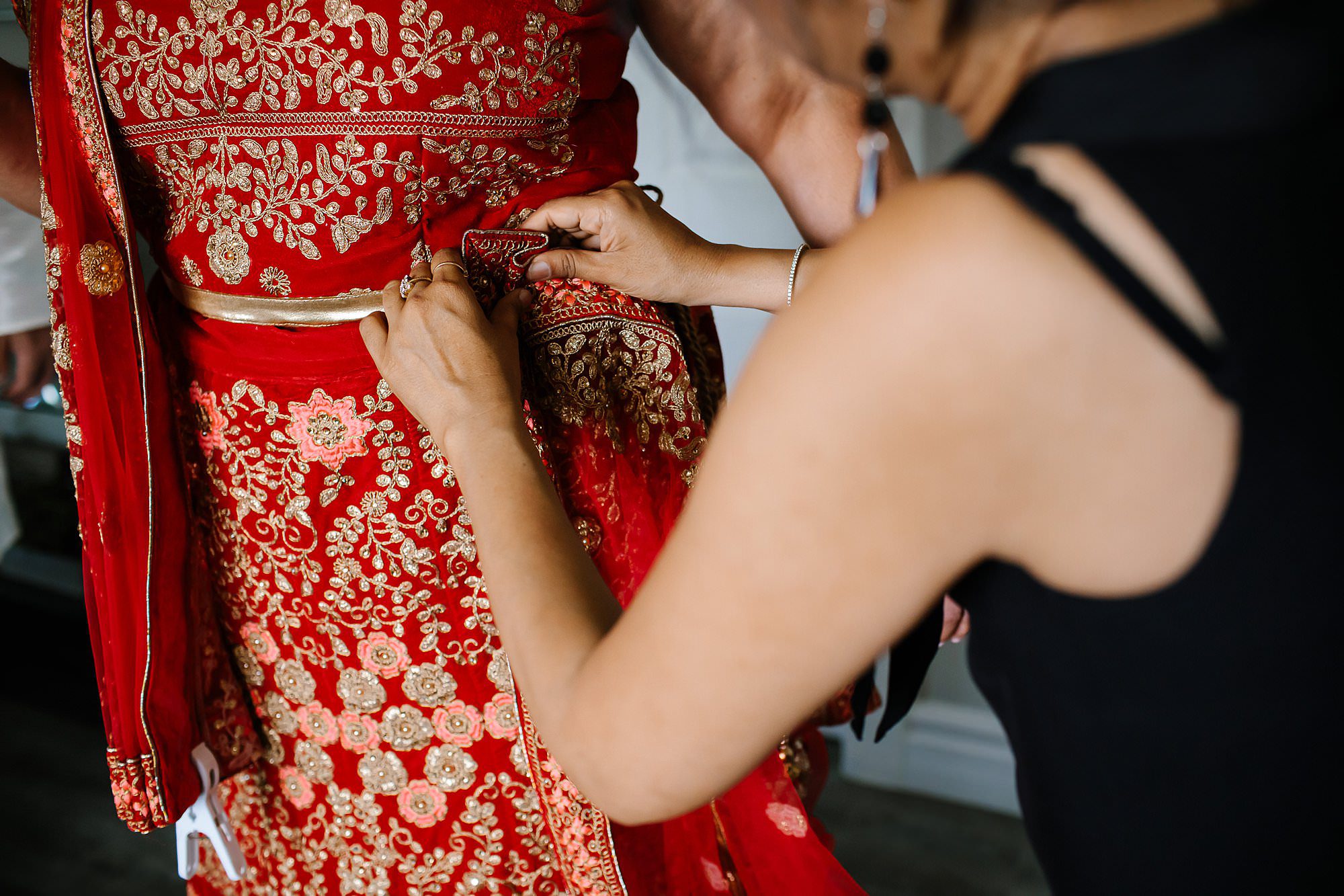 Dressing the bride in a red and gold saree