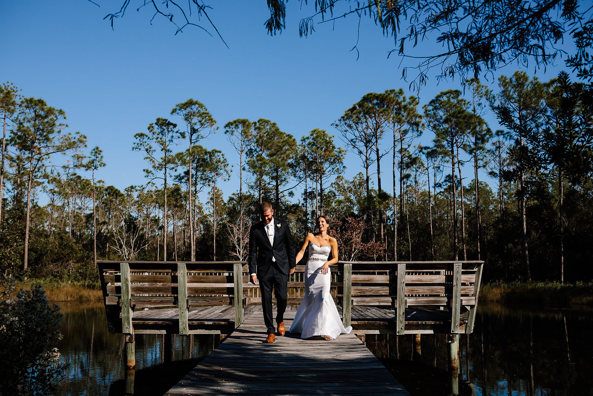 Bride and groom walking on dock near their rental house in Watercolor Florida