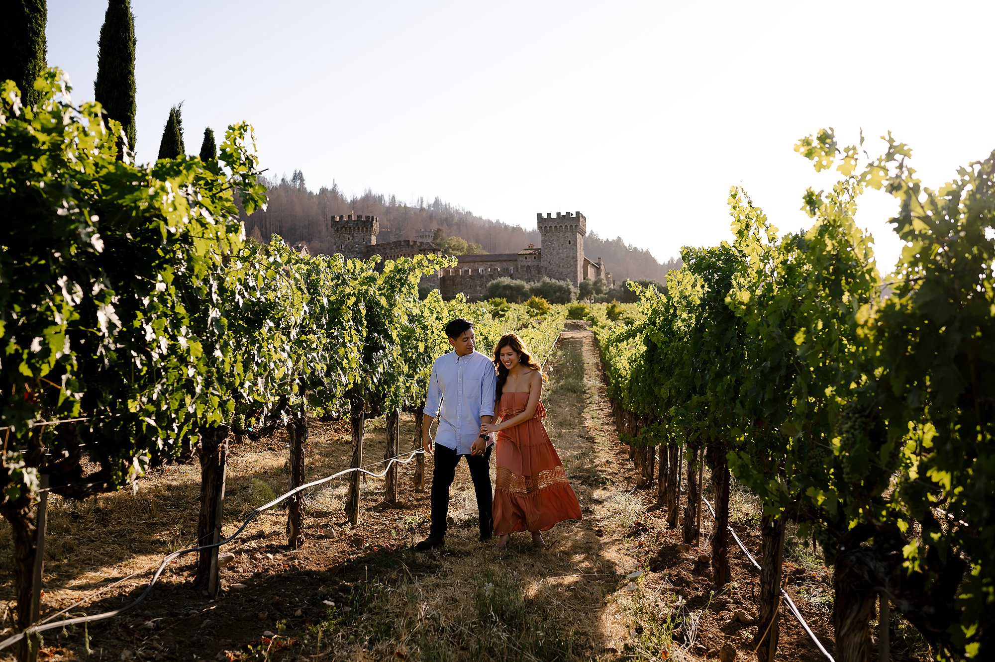 Engaged couple walking through the vineyard at Castello di Amorosa in Calistoga CA
