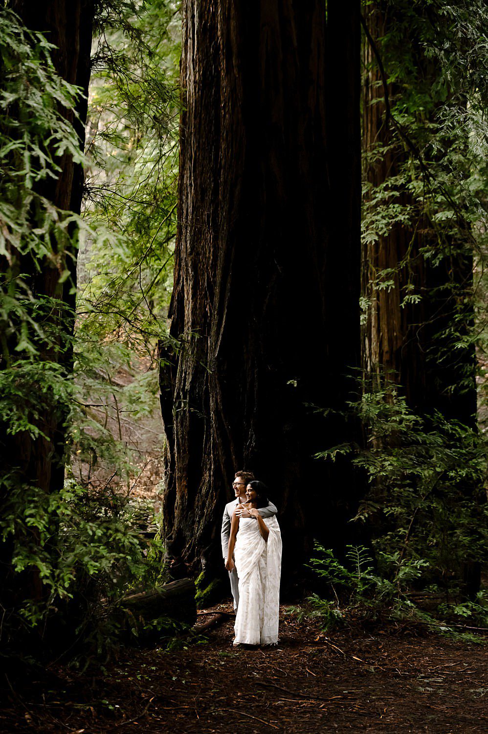Bride and groom in front of giant redwood at Armstrong National Forest