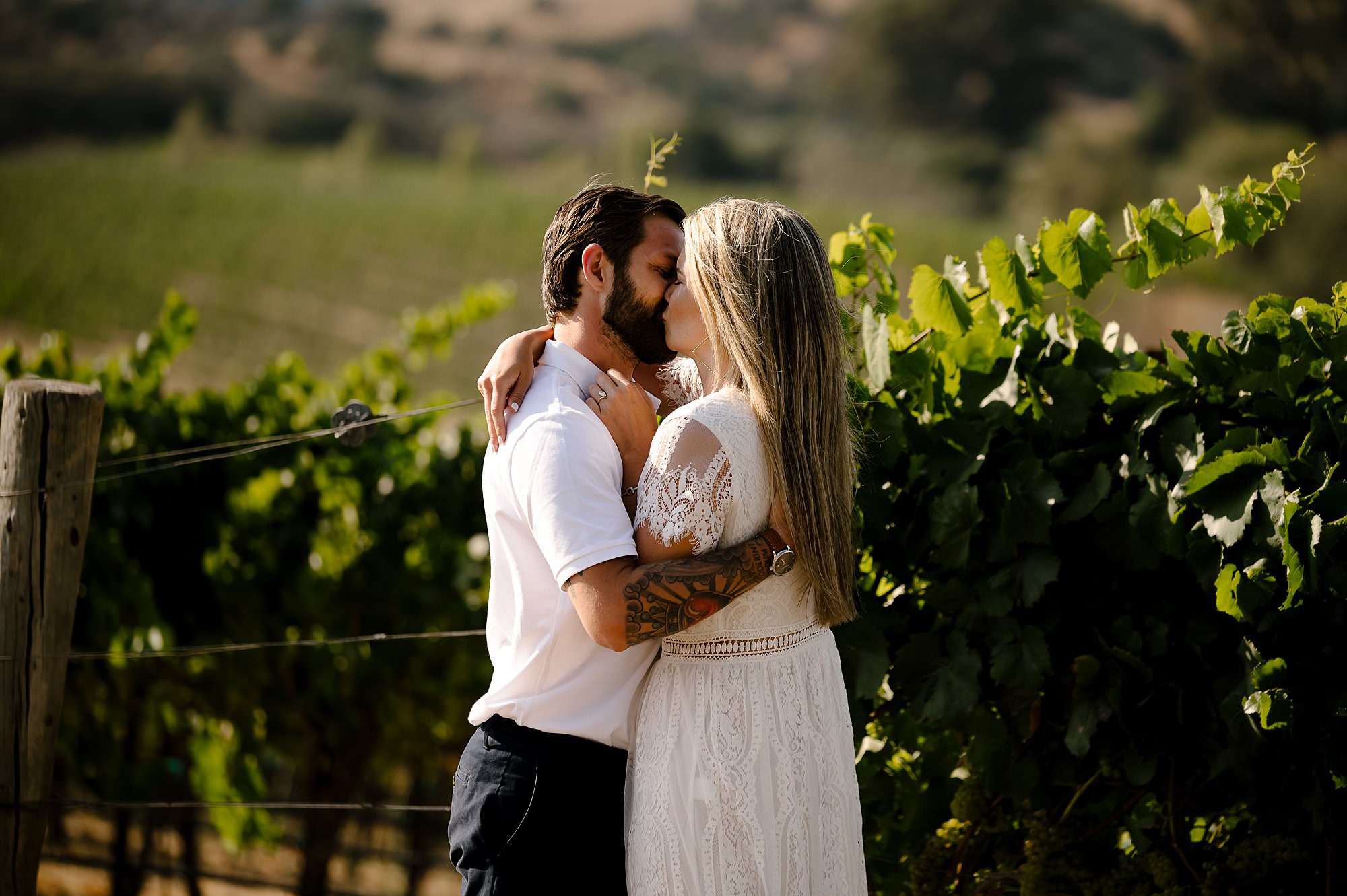 Cameron and Melissa kiss in the vineyard after Melissa accepts his proposal at Domaine Carneros in Napa.