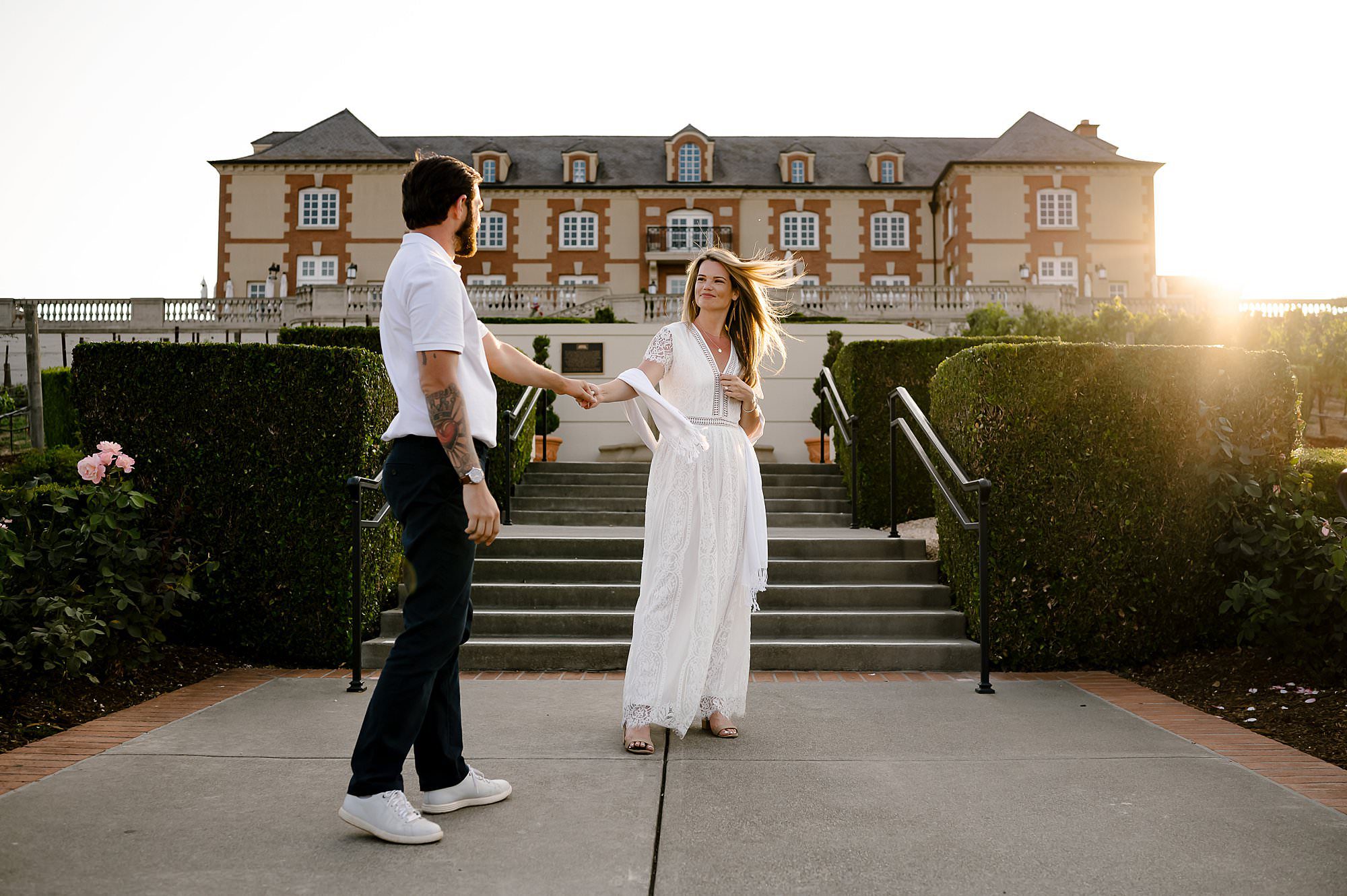 Cameron and Melissa dancing on the steps in front of Domaine Carneros during sunset. 