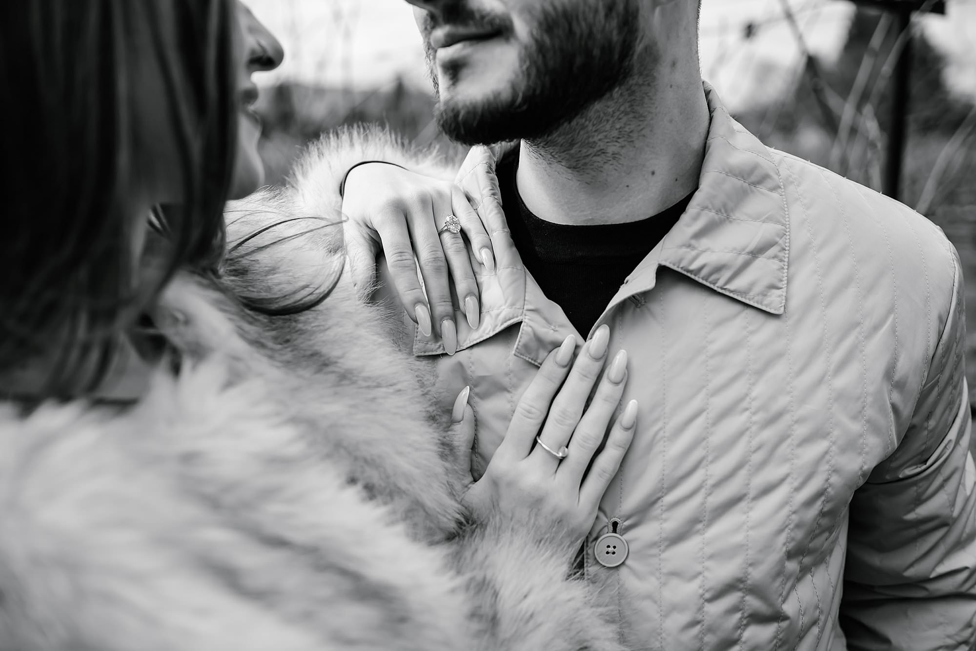 Black and white close up of Darya and Marko standing close, showing off her new engagement ring