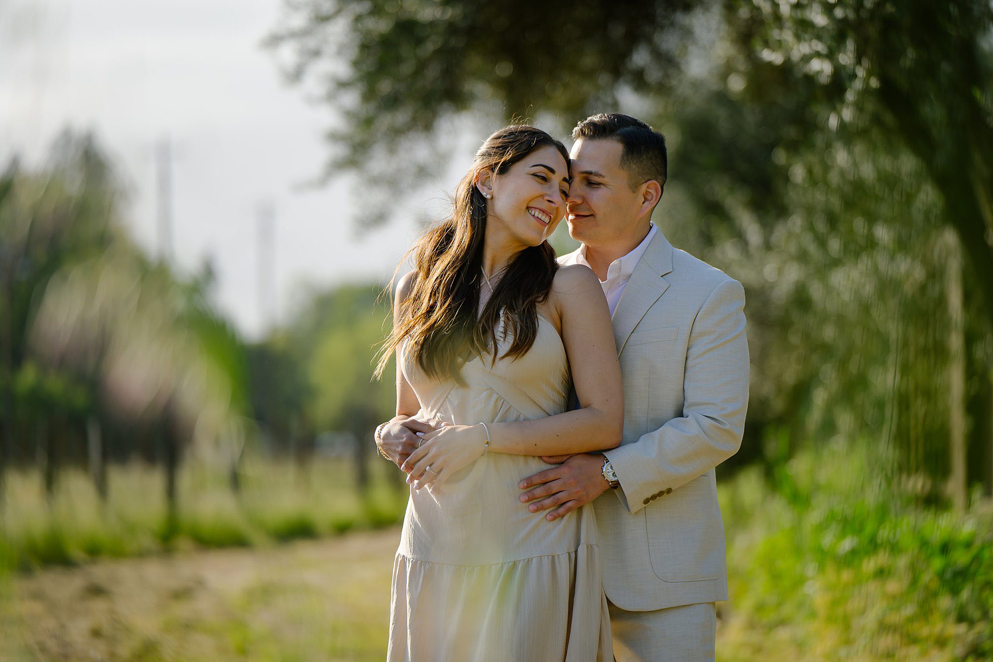Nik and Jackie nuzzle close while wandering through the vineyard at Landmark after getting engaged