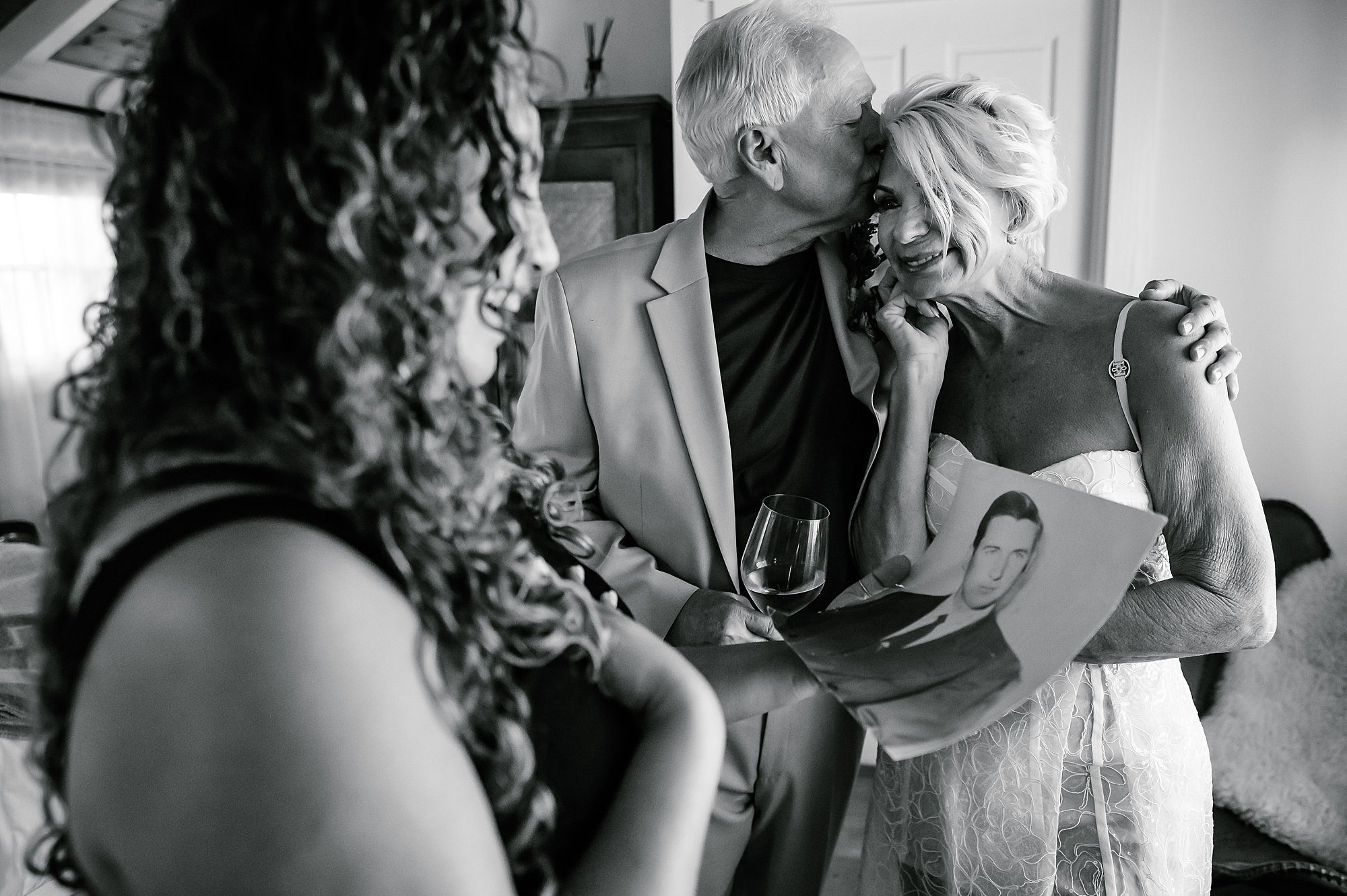 Black and white image of Barry consoling Lynn as she cries while showing her planner Samar Hattar the photo of her father.
