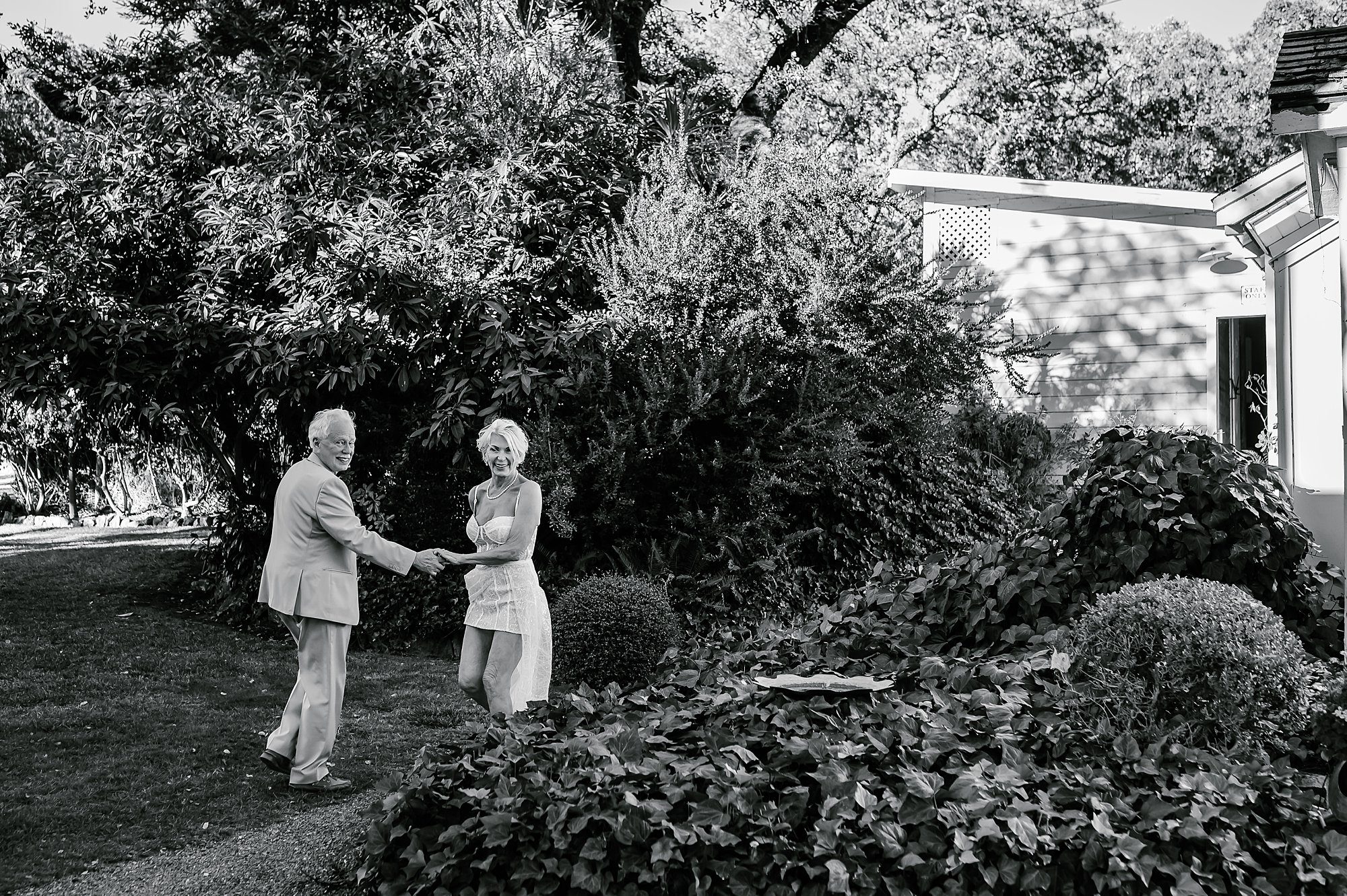 Black and white of Lynn and Barry walking back to their cottage at Beltane Ranch after their elopement in the vineyard