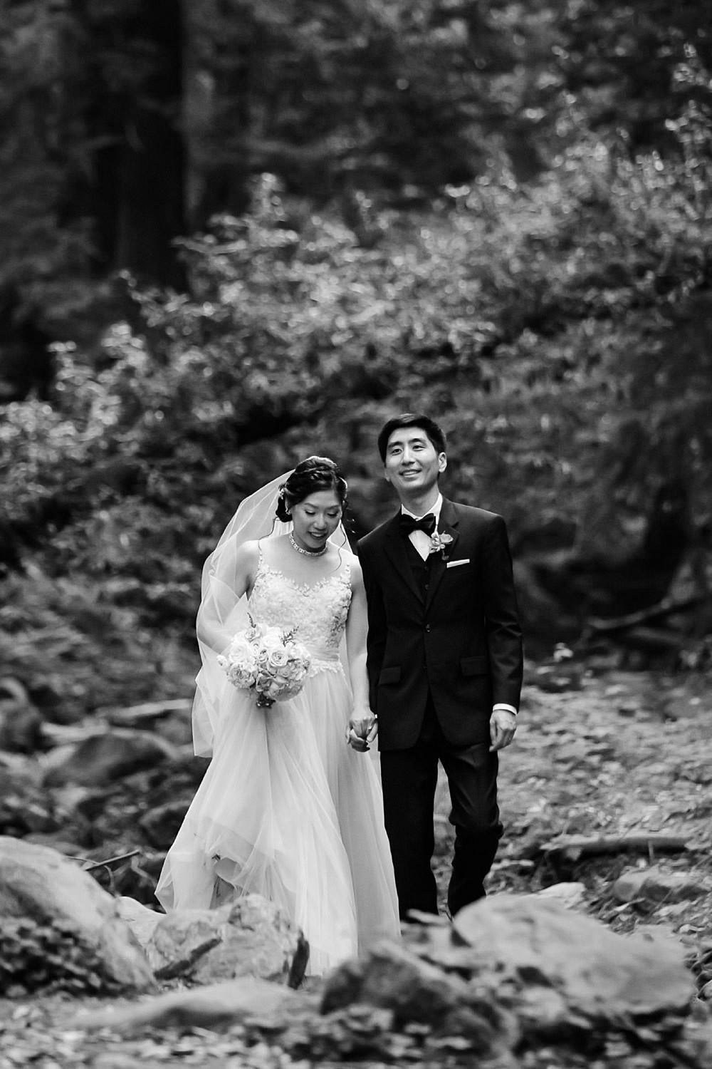 Black and white portrait of couple walking through the redwoods at Saratoga Springs for their sunset portraits