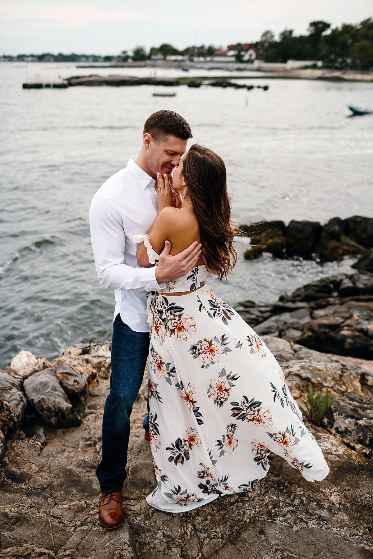 Couple standing on the rocks in front of the bay in Manor Park in Larchmont NY