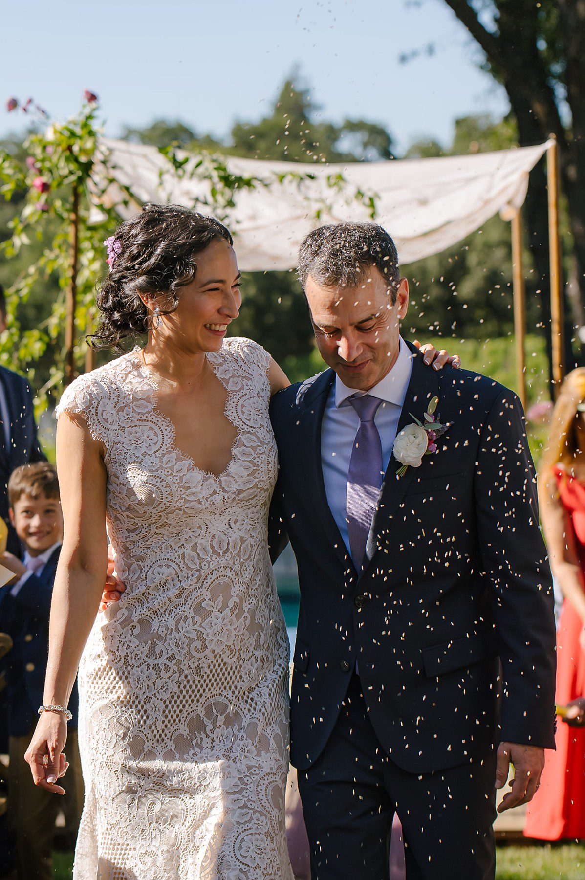 Guests toss lavender at Lara and Yoni as they walk back down the aisle of their wedding at a private estate in Windsor CA