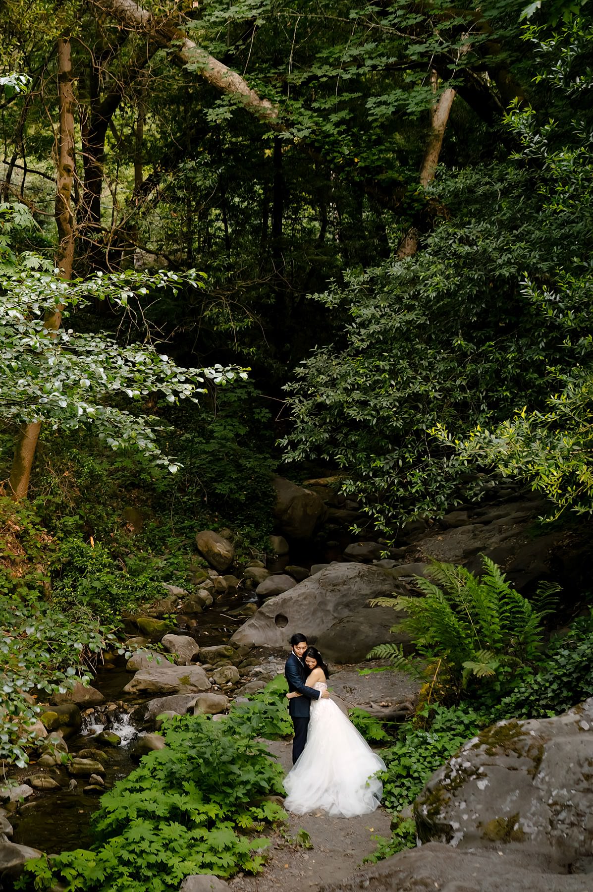 Sunset portrait of newlywed couple embracing in the canyon next to a spring at Saratoga Springs in Ca