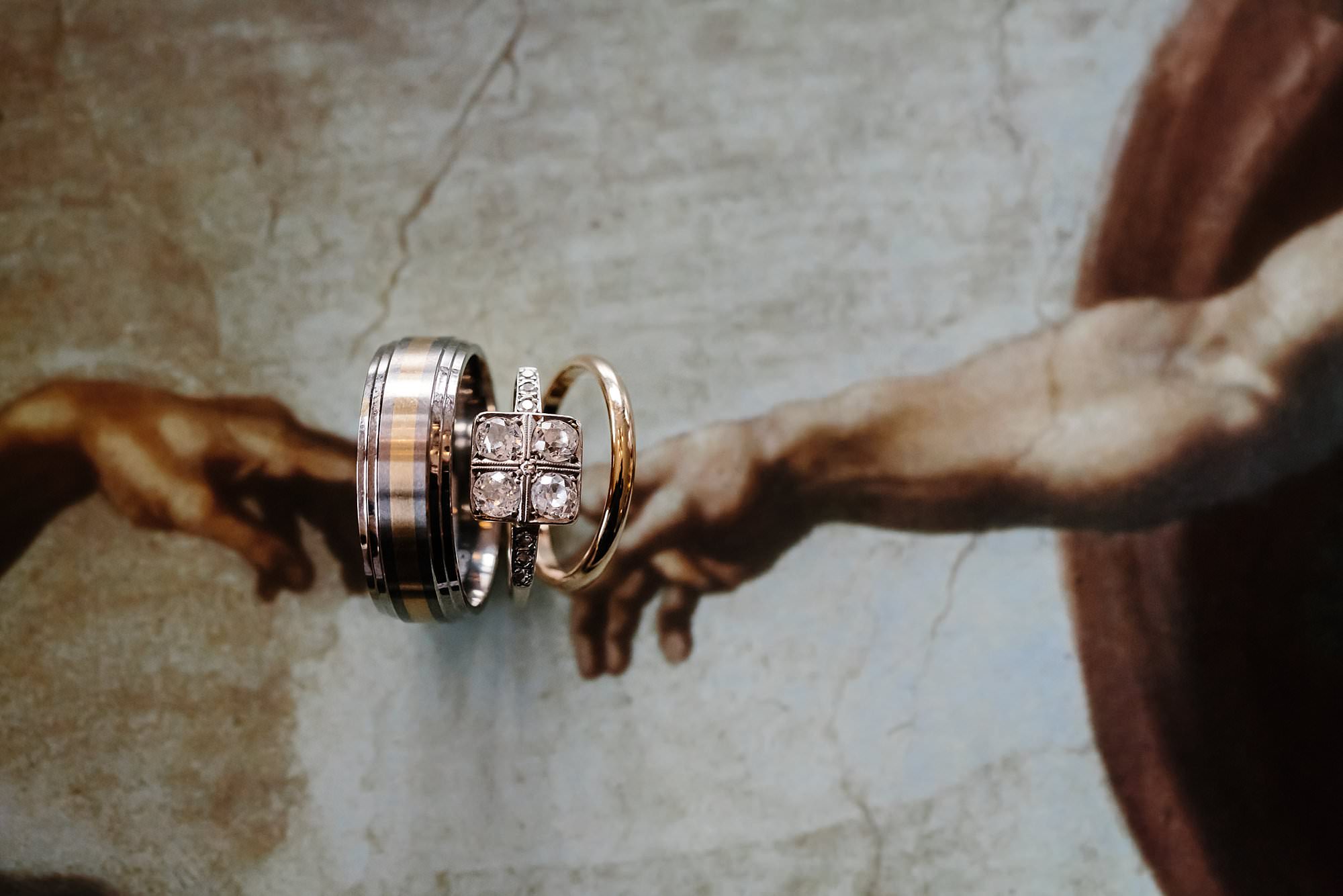 Weddings rings placed over the touching fingers of God and Adam in the famous painting The Creation of Adam by Michelangelo